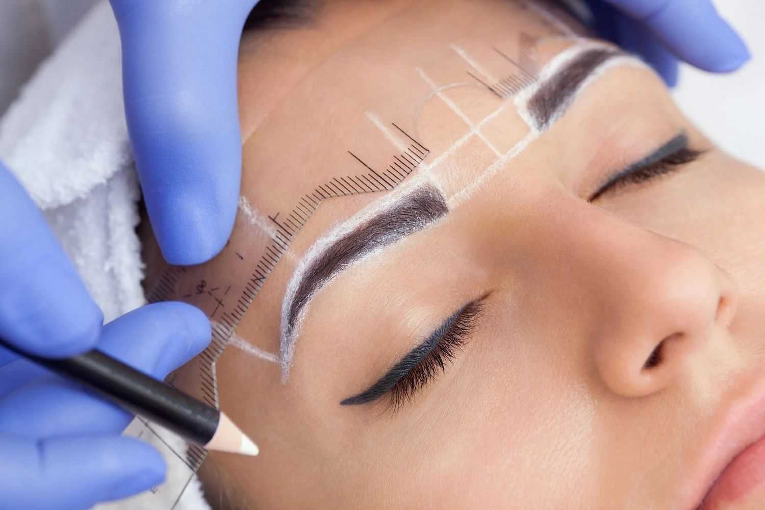 Person undergoing eyebrow marking for microblading treatment.